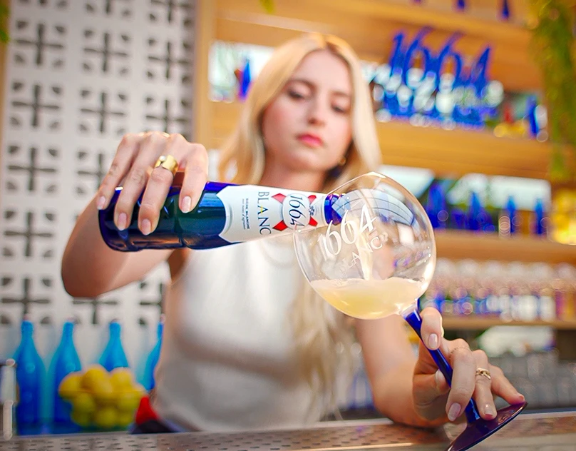 Une comédienne sert une bière 1664 Blanche au comptoir