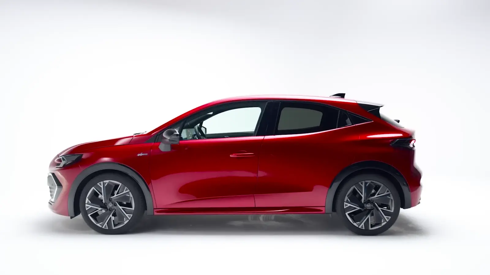 Renault Clio rouge filmée de profil sur le cyclorama blanc